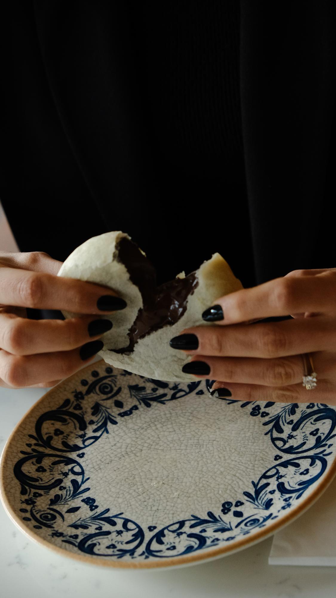 Hands seasoning a ceramic plate in a workshop kitchen